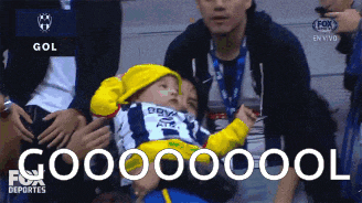 a baby in a yellow hat is being held by a man in a fox sports deportes ad