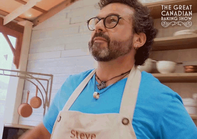 a man wearing an apron that says steve is standing in a kitchen