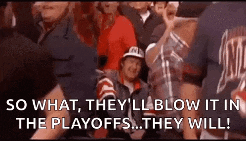 a group of people are sitting in a stadium watching a game and a man is sitting in the stands .