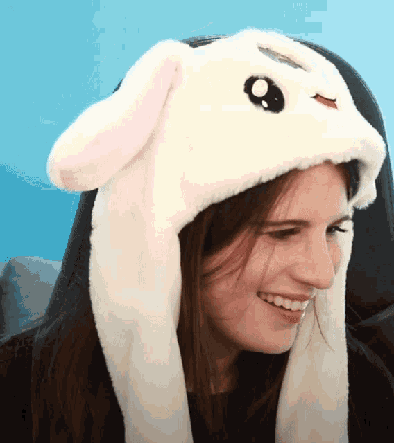 a woman wearing a white bunny hat with pink ears