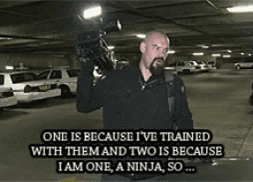 a man holding a camera in a parking garage with a caption that says one is because i 've trained with them