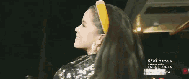 a woman wearing a yellow headband is smiling for the camera