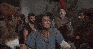 a group of men are standing together and one of them is saying " what "