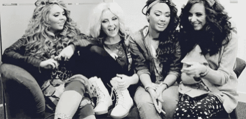 a group of girls are sitting on a couch and laughing