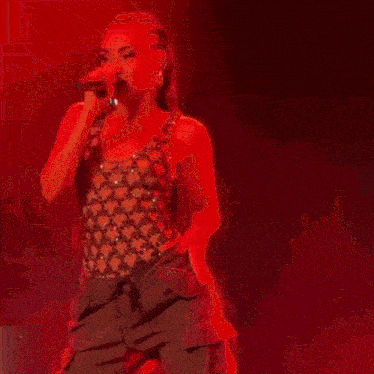 a woman with red hair is dancing on a stage with a microphone in her hand .