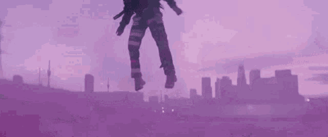 a man is flying through the air in front of a purple sky .