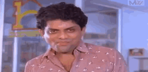 a man in a pink shirt is making a funny face while standing in front of a window .