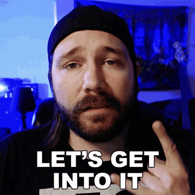 a man with a beard says let 's get into it with his finger
