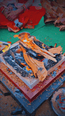 a fire is burning on a table with a woman holding a baby