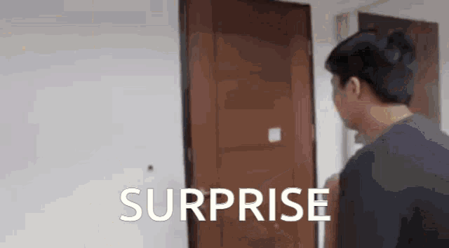 a man standing in front of a door with the word surprise written on it