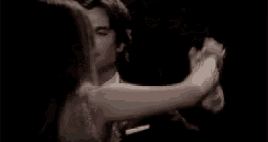 a man and a woman are dancing in a dark room .