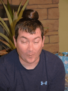 a man wearing a blue under armour shirt with a bun on his head