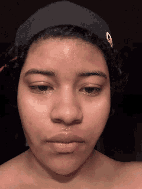 a woman wearing a hat with the letter g on it looks at the camera