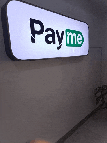 a pay me sign is hanging on a wall