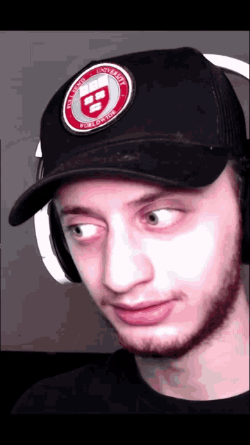 a man wearing a hat with a patch that says harvard university