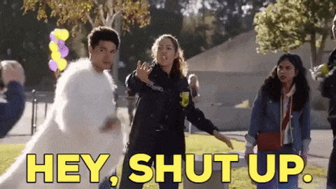 a group of people are standing in a field with the words `` hey , shut up '' written on the screen .