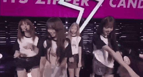 a group of young women are dancing on a stage in front of a purple sign that says candy .