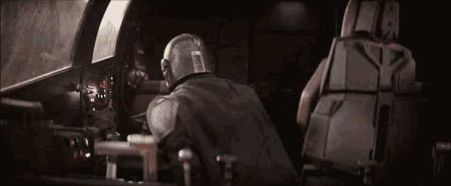 a man wearing a helmet is sitting in the cockpit of a space ship .