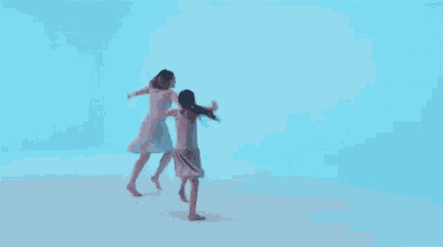 a woman and a little girl are dancing together in a blue room .