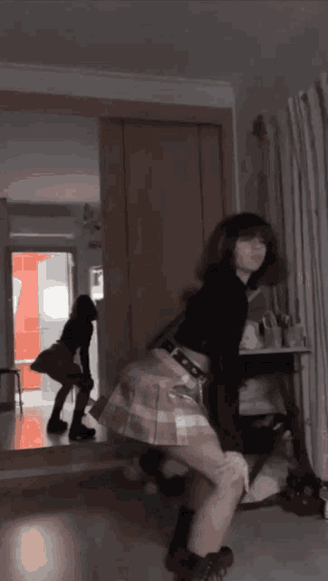 a girl is dancing in front of a mirror in a room