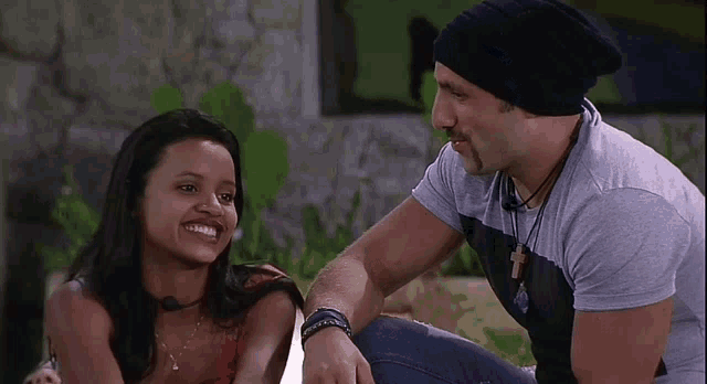 a man and a woman are sitting next to each other and the woman is smiling