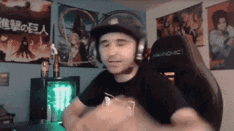 a man wearing headphones and a helmet is sitting in a chair in a room .