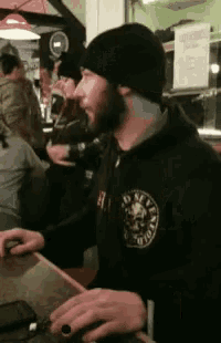 a man wearing a black hoodie with a skull on the front