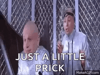 two bald men are standing next to each other in front of a fence and talking .