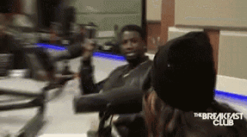 a man in a black hat is sitting in front of a microphone with the breakfast club written on the bottom