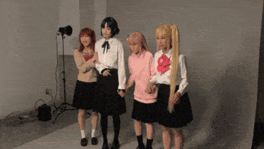 a group of girls standing next to each other with one wearing a pink sweater with a heart on it