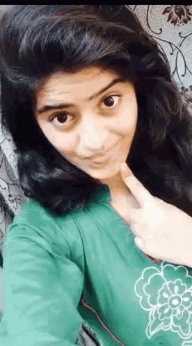 a girl is taking a selfie with her finger on her chin