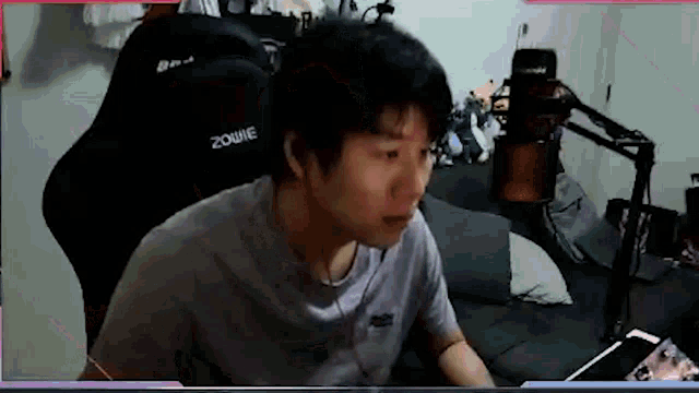 a man is sitting in a chair in front of a computer in a room .