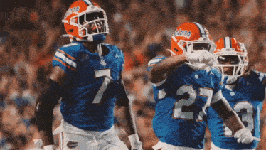 a group of florida gators football players are celebrating a touchdown