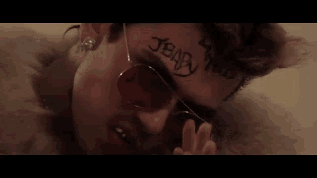a man has a tattoo on his face that says jbaby
