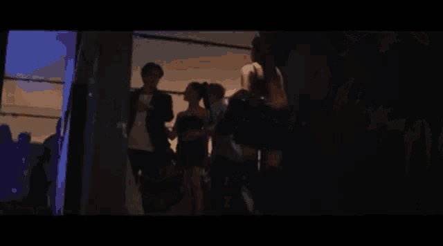 two women are standing next to each other in a dark room looking at each other .