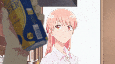 a can of beer is being held up by a girl