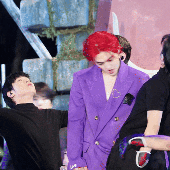 a man with red hair is wearing a purple jacket with the word live on the sleeve