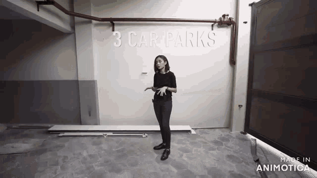 a woman stands in front of a wall that says " 3 car parks "