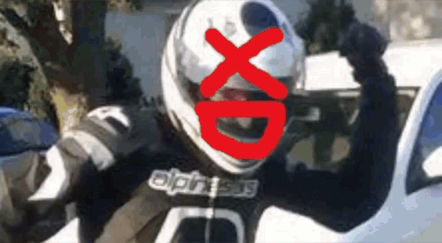 a person wearing a motorcycle helmet with a red xd on it