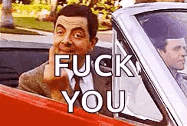mr bean is driving a red car and making a funny face and saying `` fuck you '' .