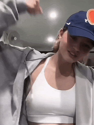 a woman wearing a white bra and a blue hat