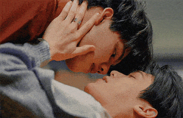 two men are kissing and one has a ring on his finger