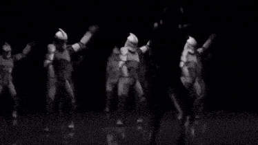 a group of clone trooper soldiers are dancing in a black and white photo .