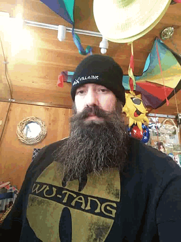 a man with a beard is wearing a wu tang shirt