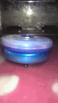 a close up of a blue yoyo on a pink surface