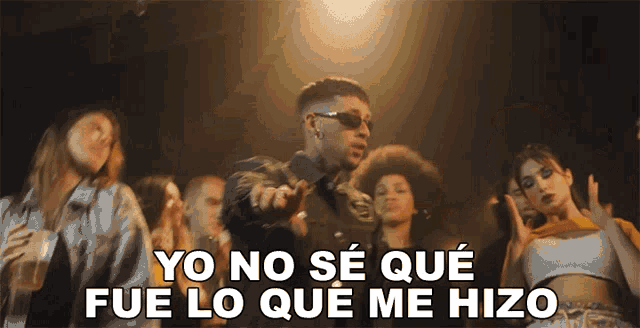 a group of people are dancing and the words yo no se que fue lo que me hizo are visible