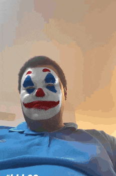 a man wearing a clown mask and a blue shirt