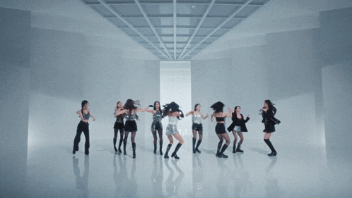 a woman in a silver top is surrounded by other women in black