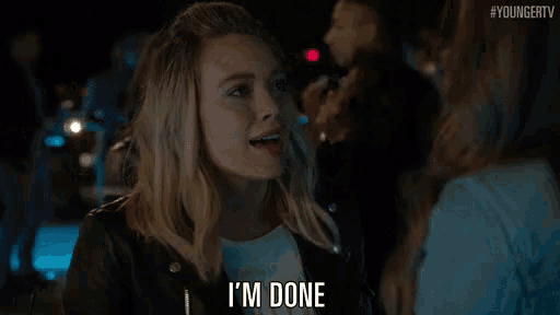 a woman is smiling and saying i 'm done in a bar .