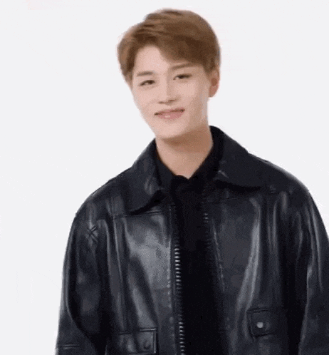 a young man wearing a black leather jacket and a black shirt .